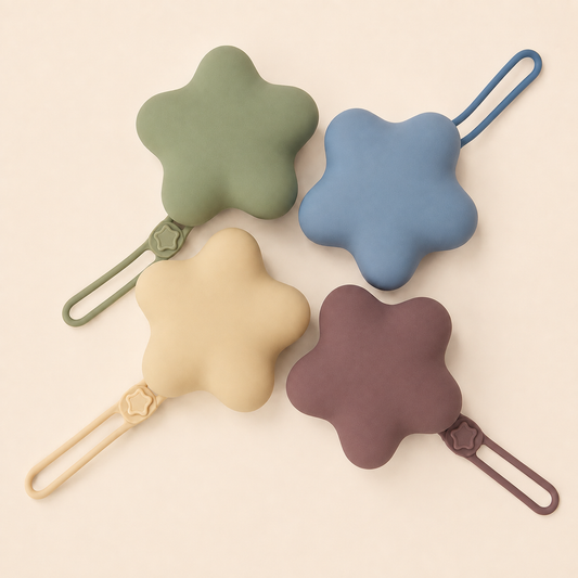 Star-shaped silicone pacifier cases in sage green, dusty blue, beige and dusty mauve, each with a flexible hanging strap.