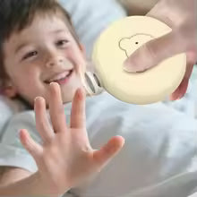 Smiling toddler using the Bloom & Bear electric baby nail trimmer safely at home